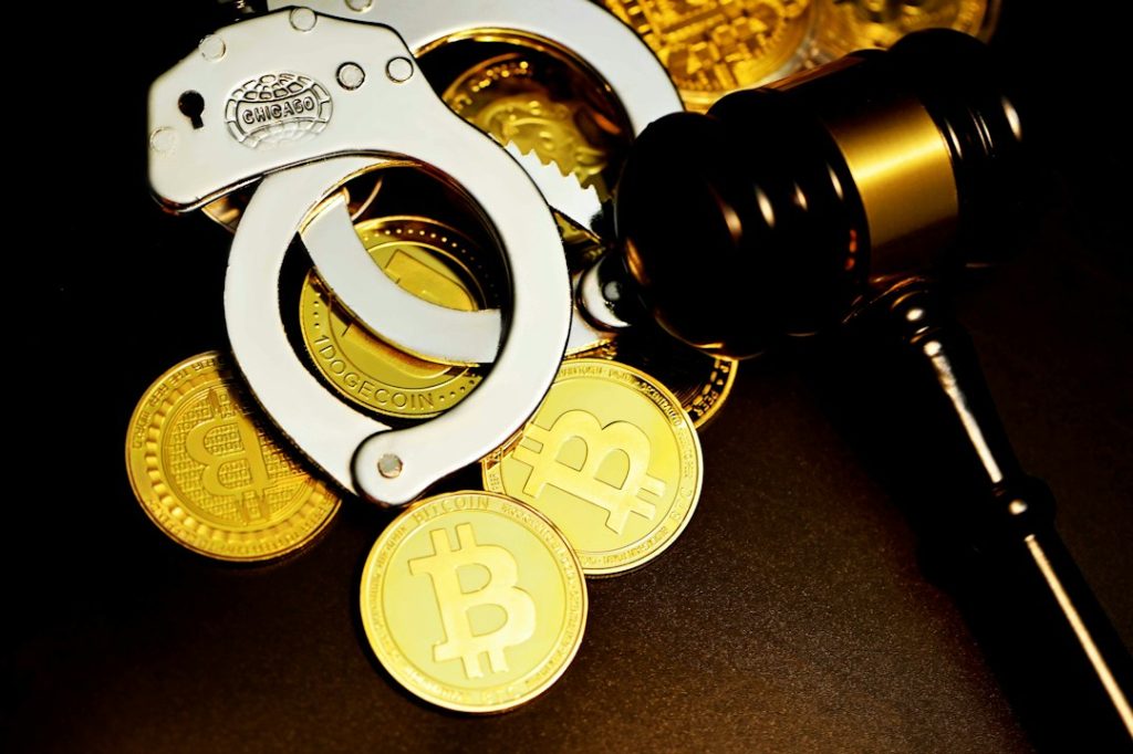 A handcuff is next to the hammer court on top of bitcoin